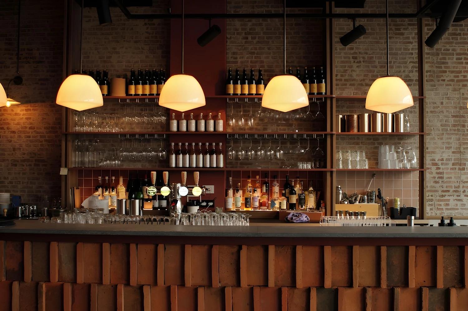 Bar élégant du Conscious Hotel The Tire Station avec des lumières chaleureuses.