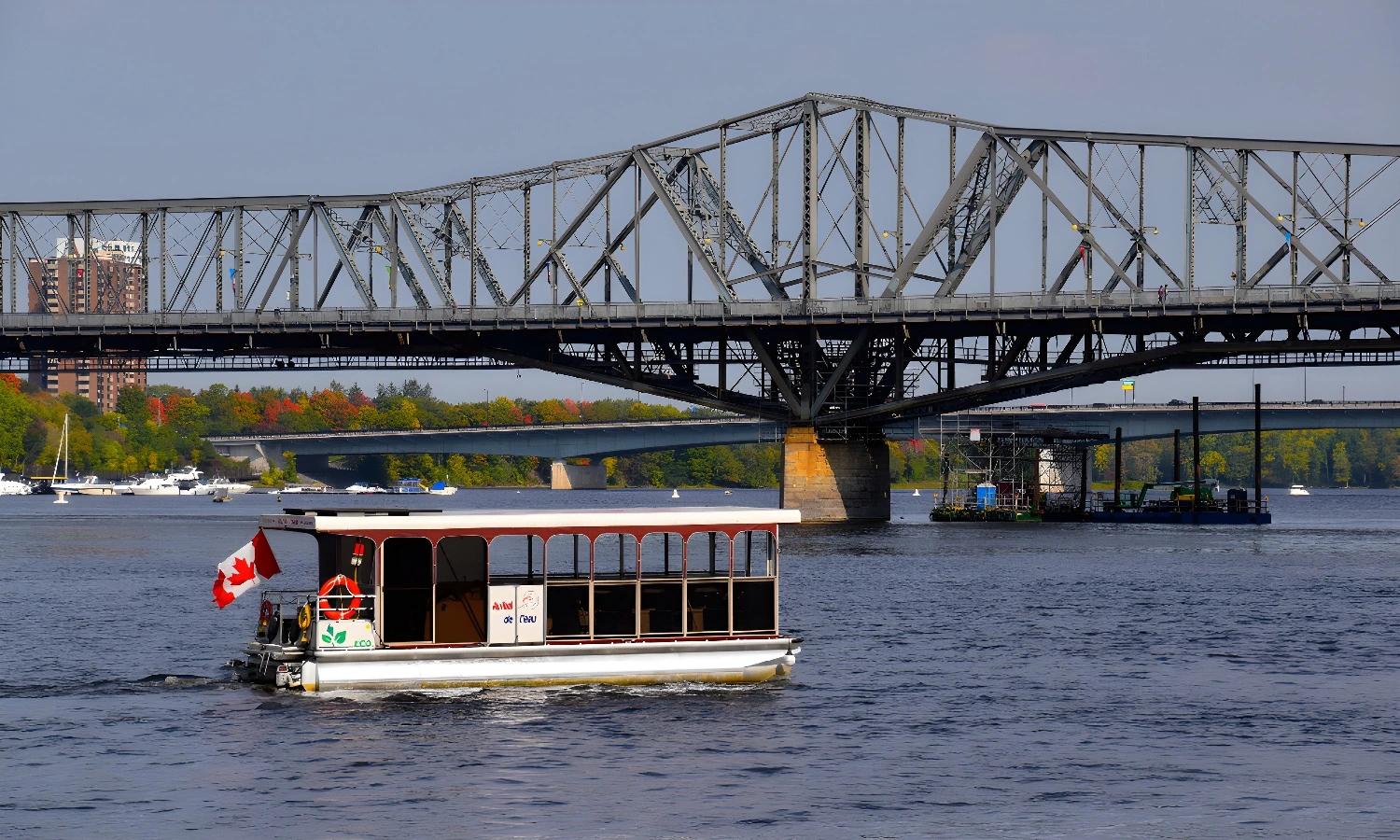 Bateau sur le fleuve Saint-Laurent avec pont en arrière-plan sur la route des explorateurs au Québec