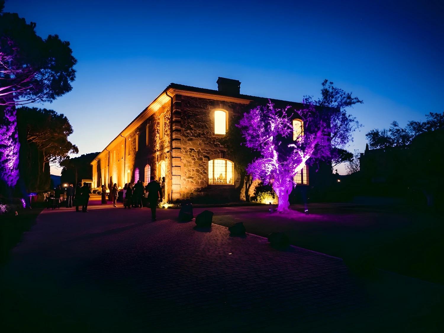 Bâtiment de L'Andana Resort illuminé la nuit avec éclairage violet.