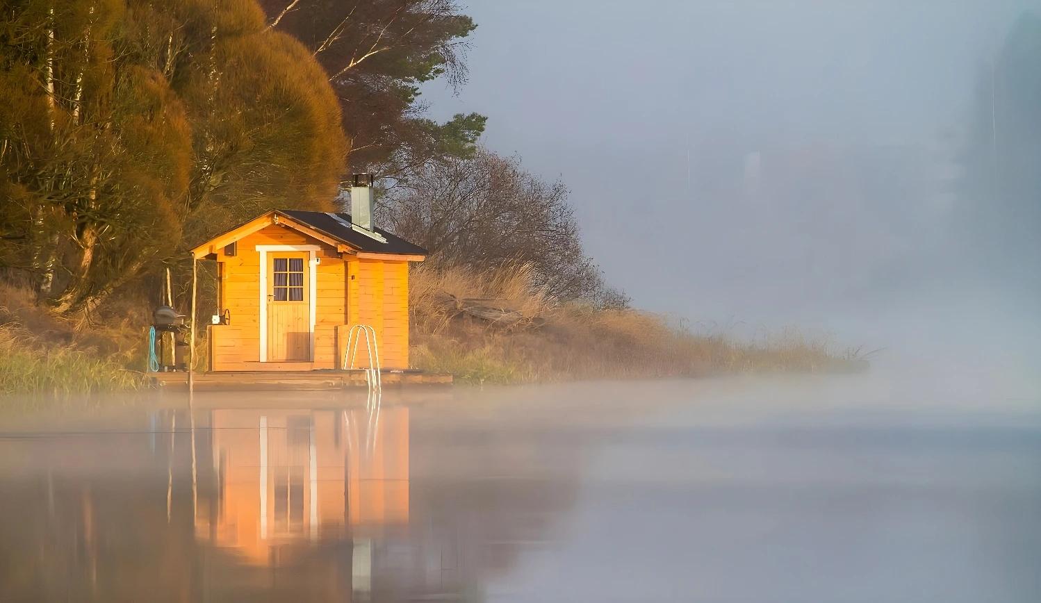 Cabane en bois au bord d'un lac embrumé, Rêves d'été en Laponie