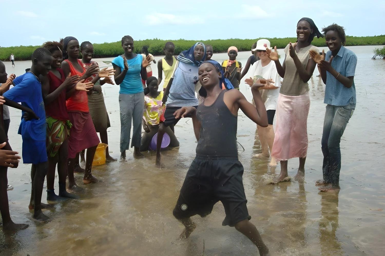 En famille au Siné Saloum : groupe de personnes célébrant dans l'eau