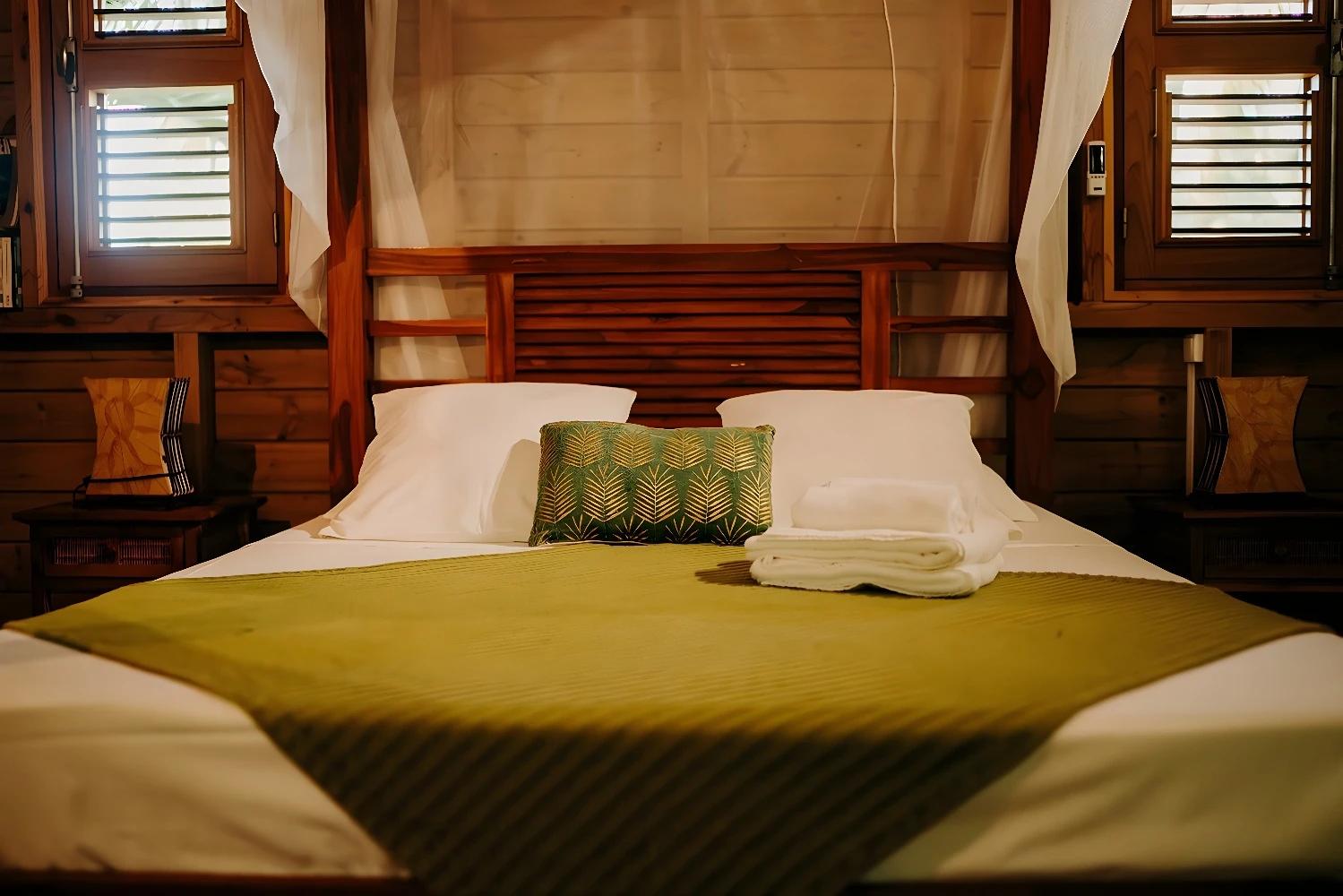 Chambre confortable avec décoration en bois à Caraib Bay