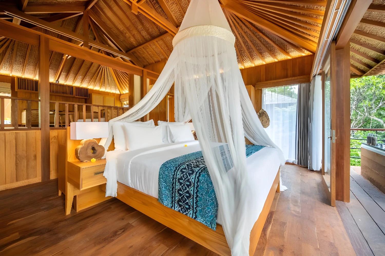 Chambre en bois avec lit à baldaquin au Kappa Senses Ubud