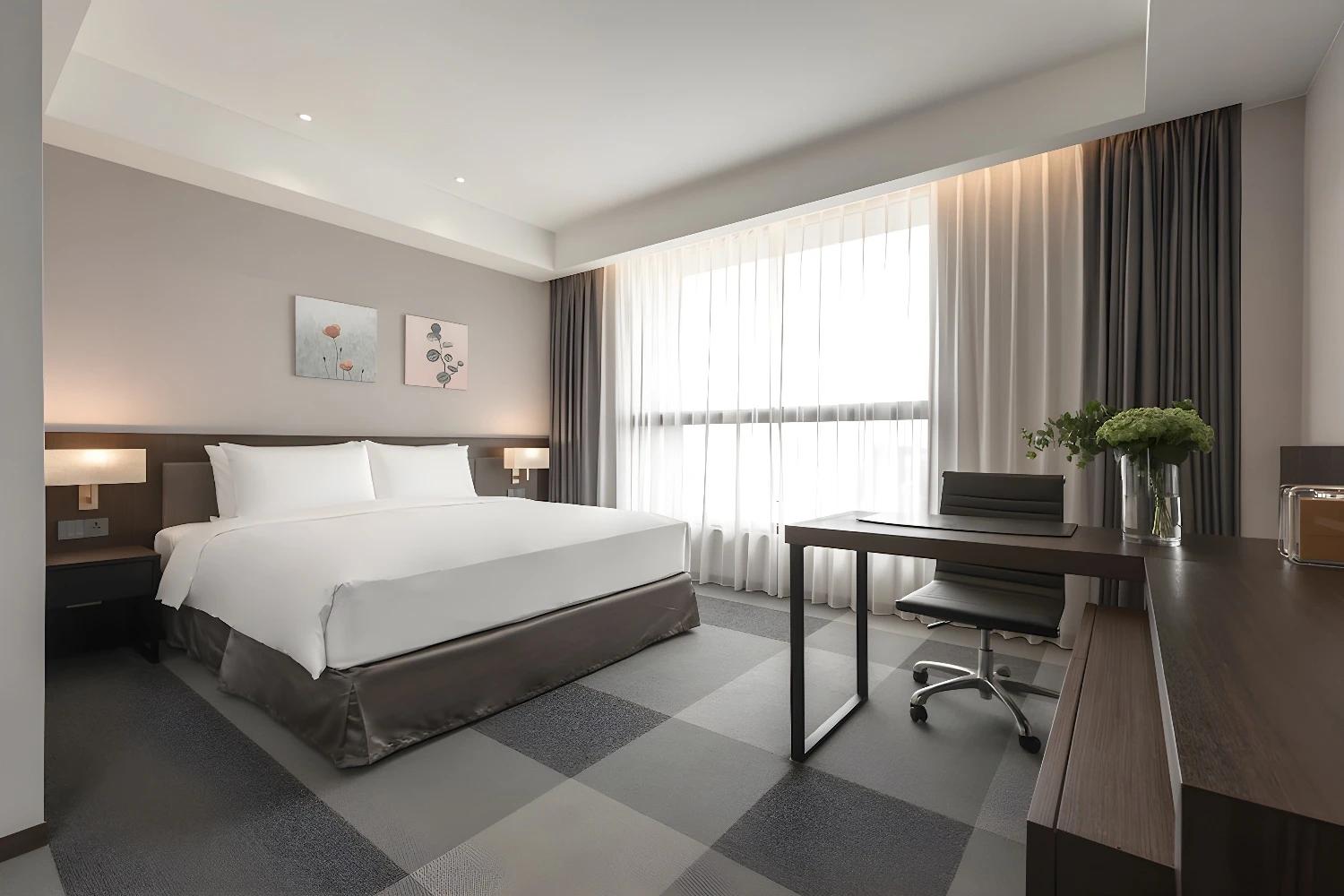 Chambre double moderne au Lakeshore Hotel Tainan avec bureau et grande fenêtre.