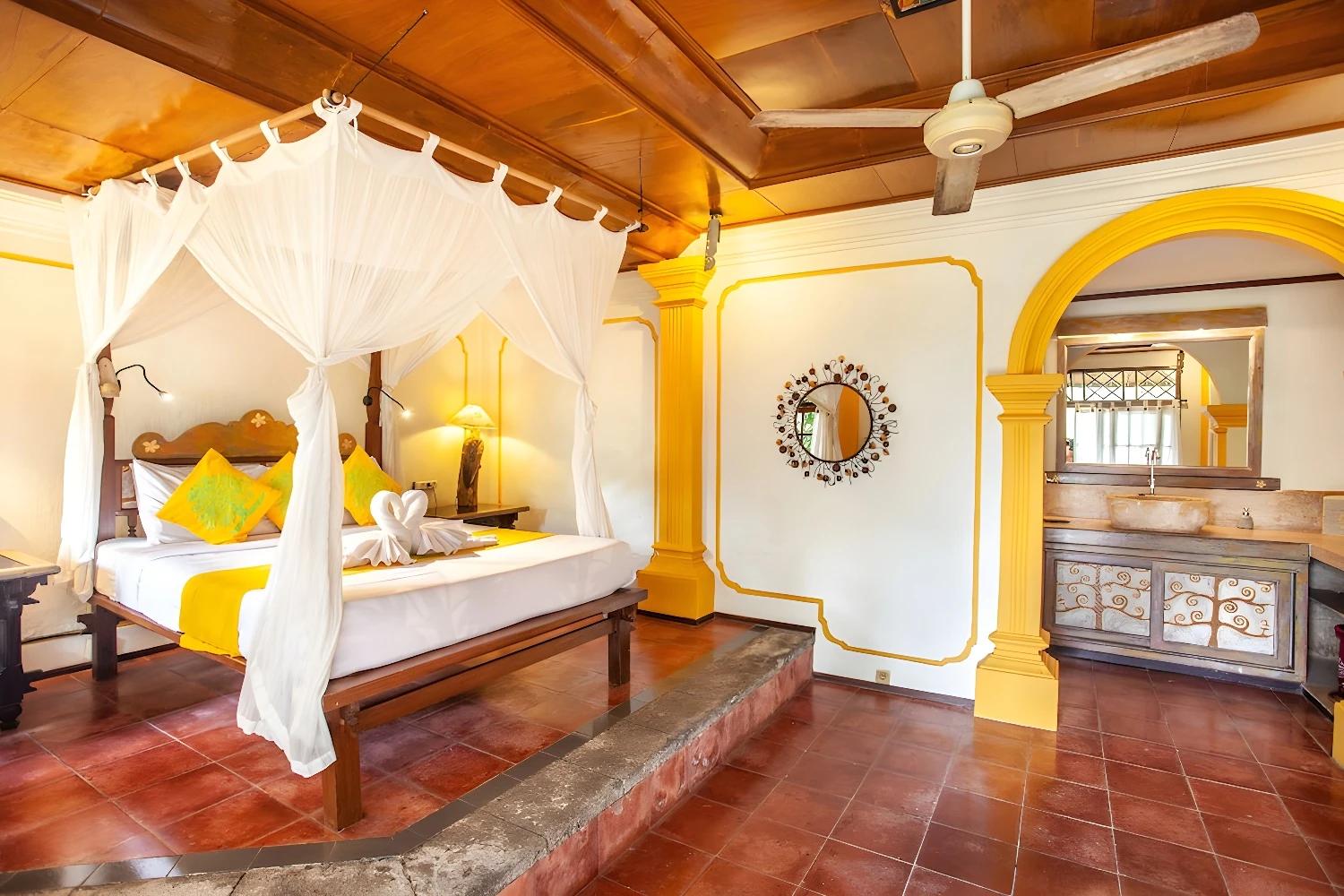 Chambre intérieure du Swasti Eco Cottage avec lit à baldaquin et décoration chaleureuse.