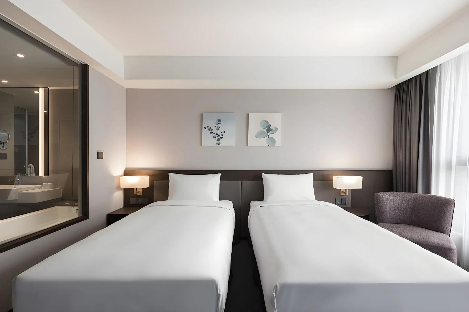 Chambre avec deux lits simples au Lakeshore Hotel Tainan, vue sur la salle de bain.