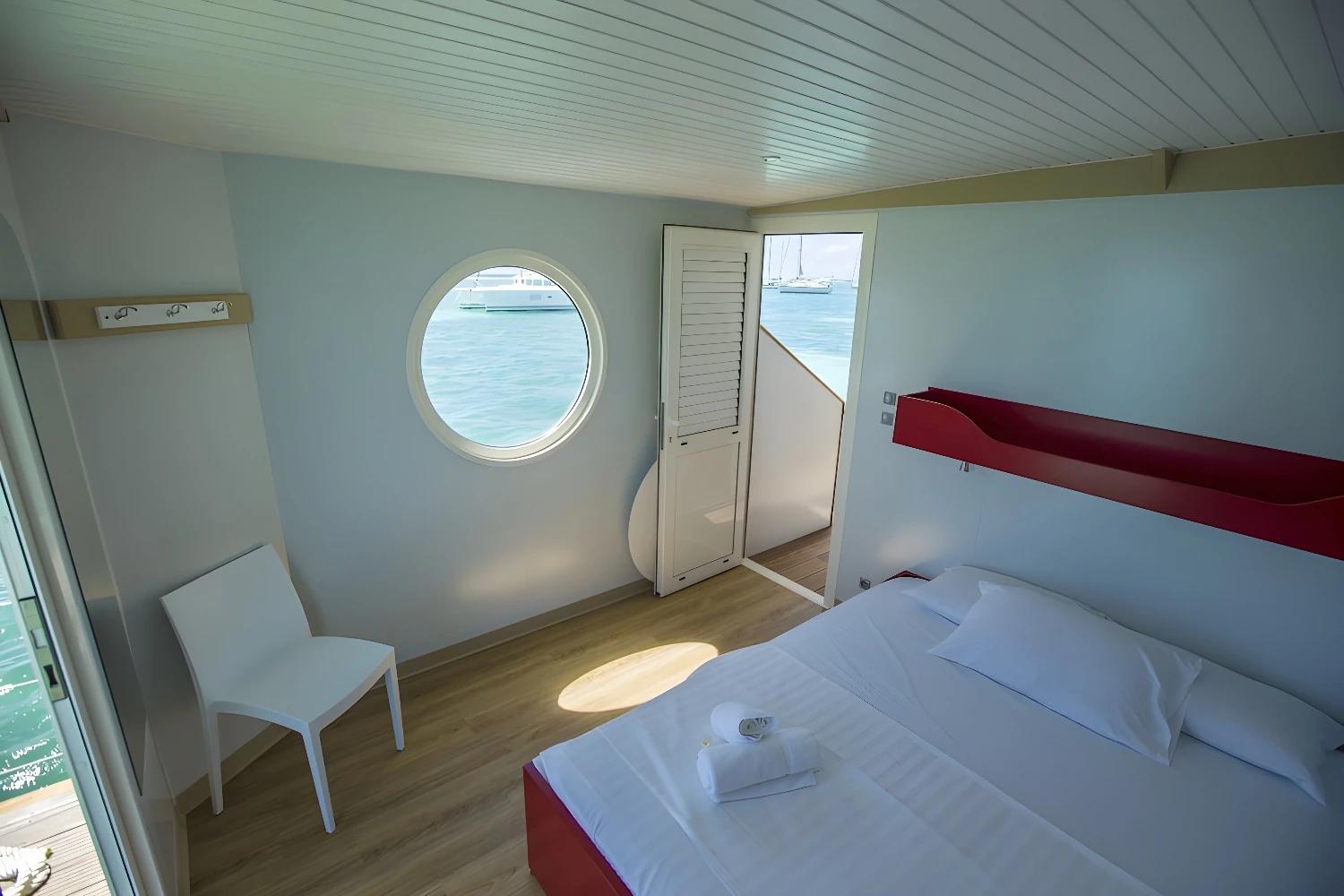 Chambre lumineuse de l'Aqua Lodge avec vue sur la mer.