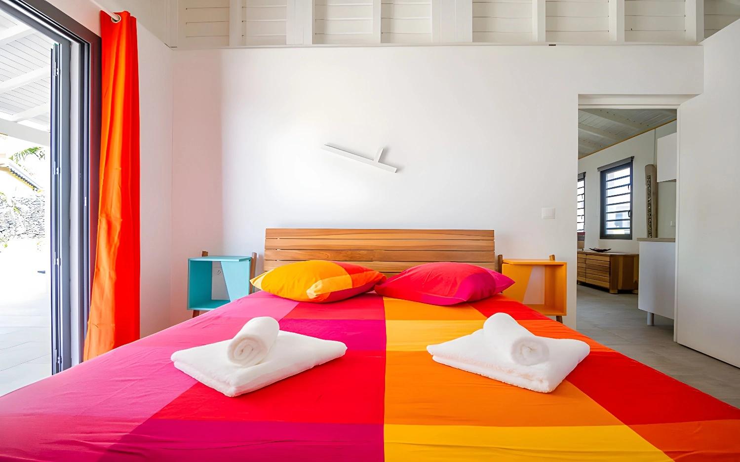 Chambre lumineuse à Iguane House Villas & Spa avec décor coloré.