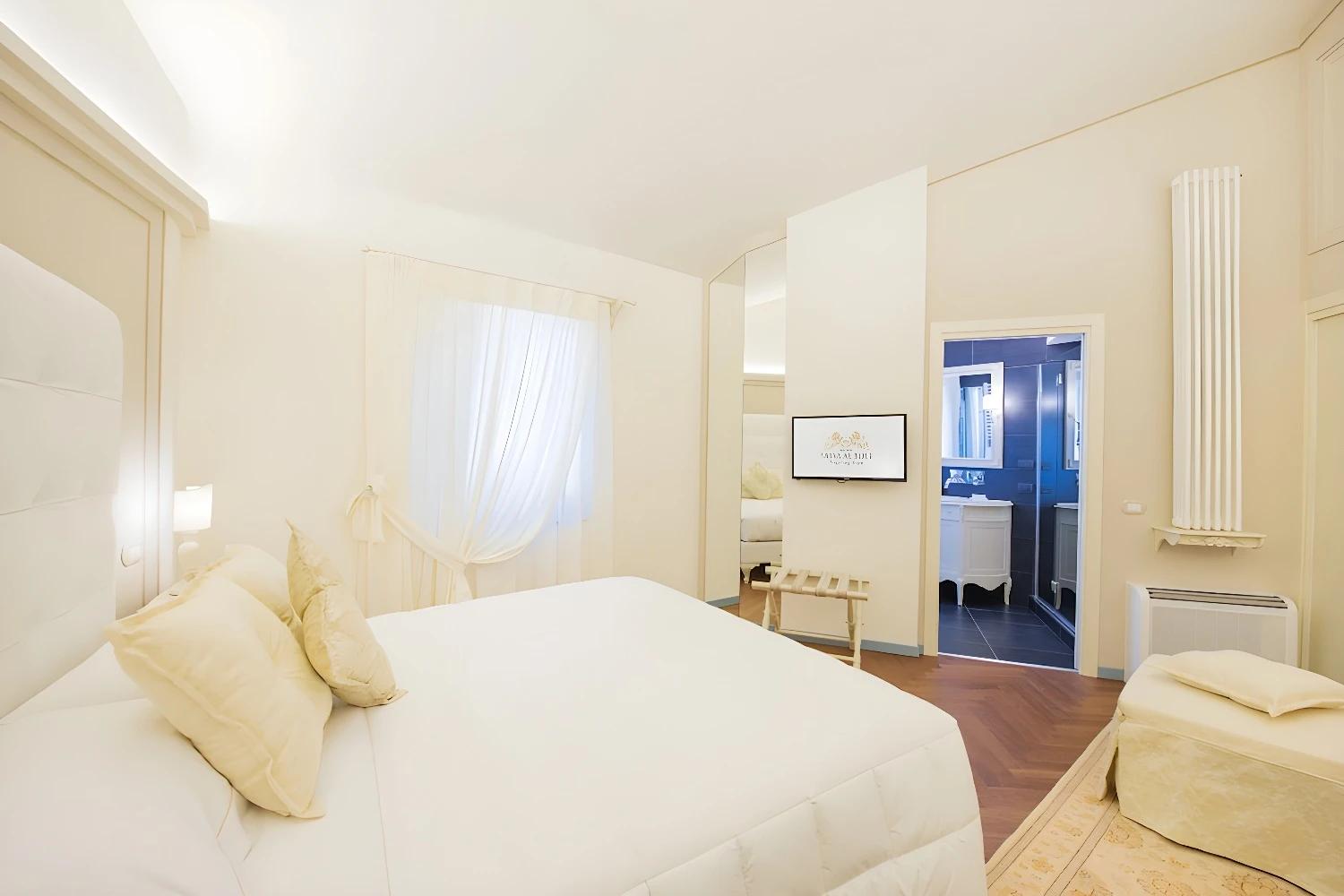 Chambre lumineuse au Relais Sassa al Sole avec lit double et décoration élégante.