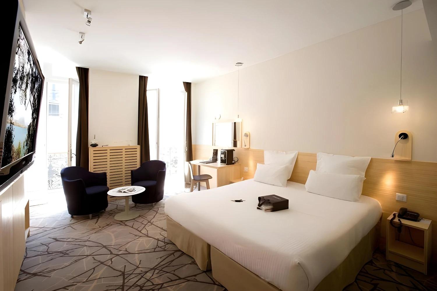 Chambre spacieuse et lumineuse du BW Grand Hôtel Français avec grand lit et coin salon.