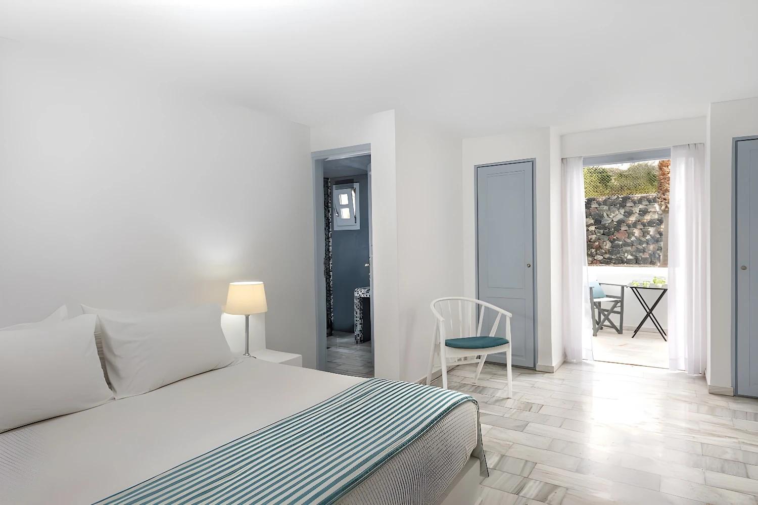 Chambre spacieuse avec lit double et accès à la terrasse au Santorini Kastelli.