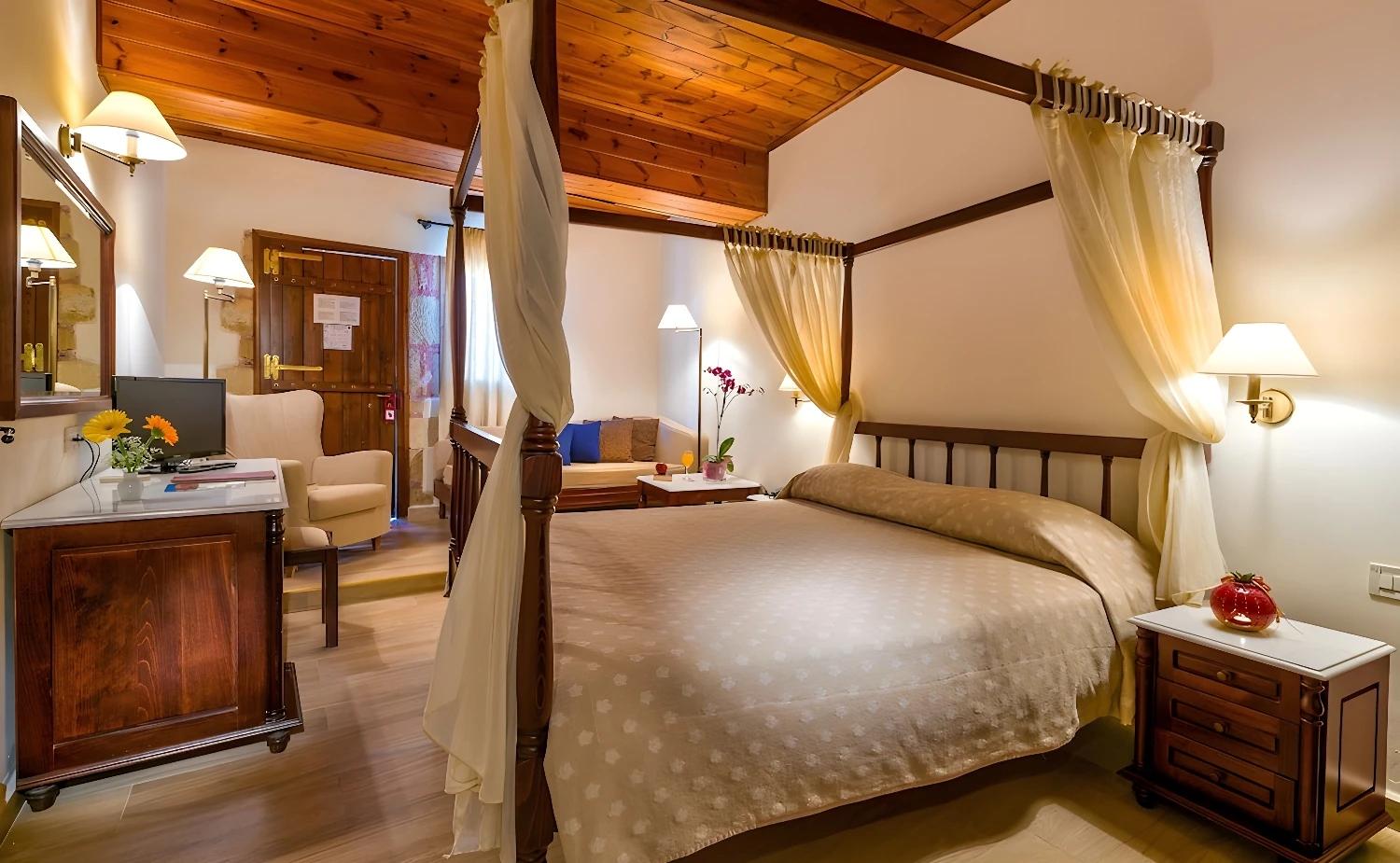 Chambre confortable avec lit à baldaquin au Spilia Village.