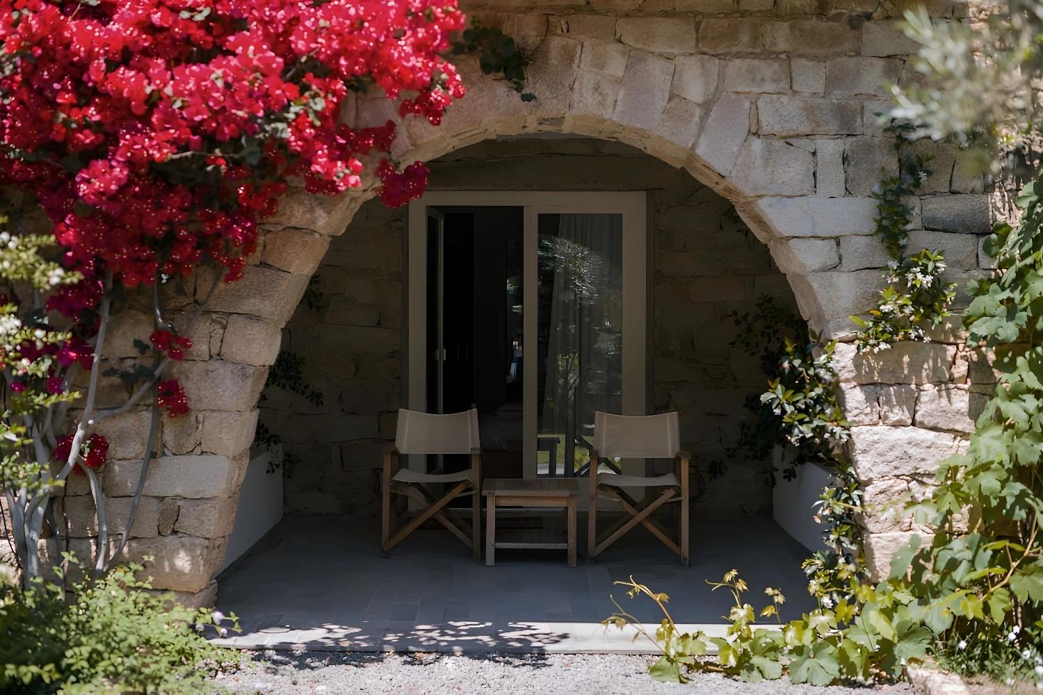 Entrée fleurie du Lanthia Resort avec arche en pierre.