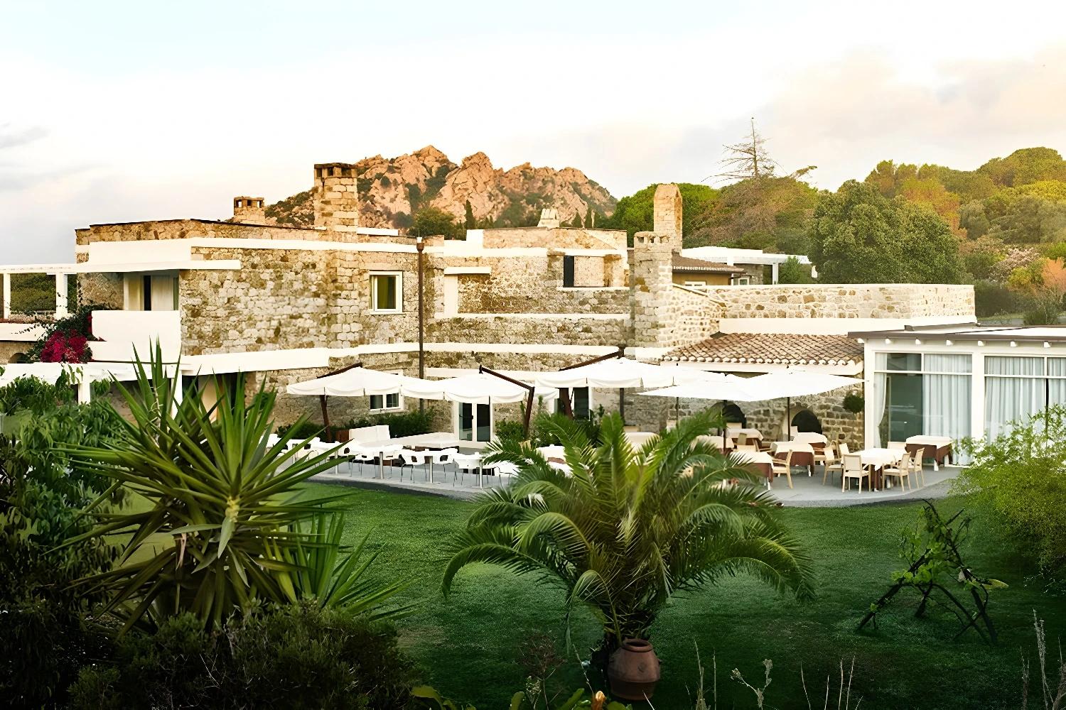 Vue extérieure du Lanthia Resort avec architecture en pierre et végétation luxuriante.