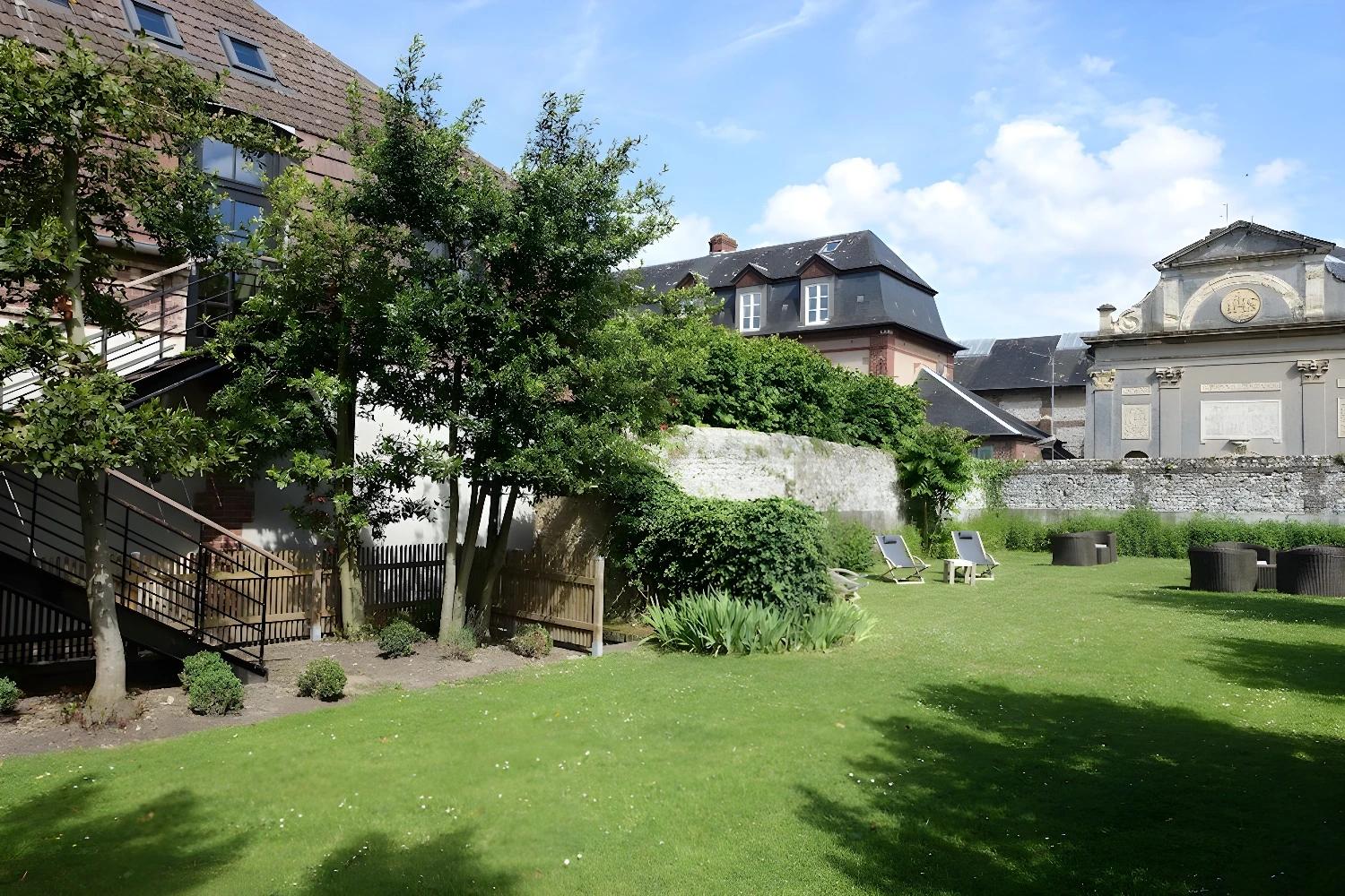 Jardin paisible des Maisons de Léa avec chaises longues