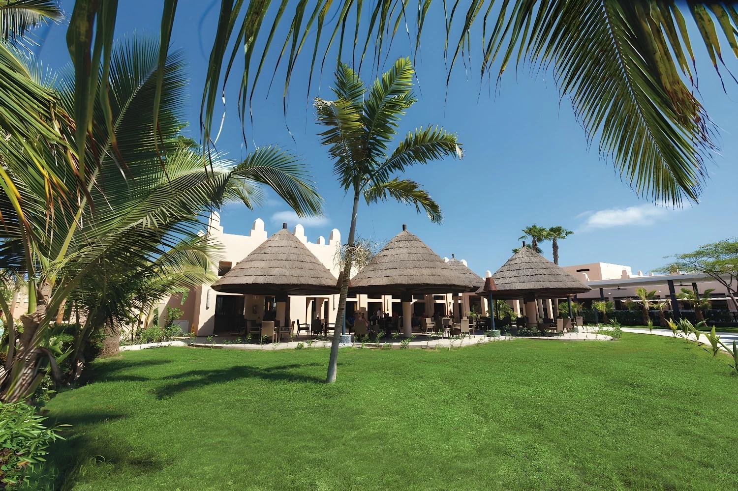 Jardin verdoyant du Riu Cabo Verde - Adult Only avec huttes traditionnelles.
