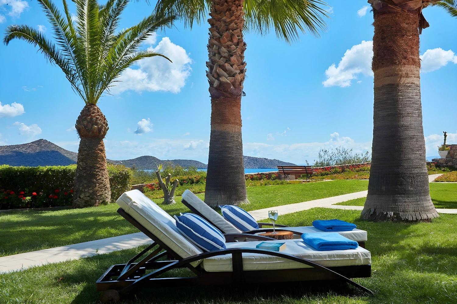 Jardin avec transats à l'Elounda Palm Hotel
