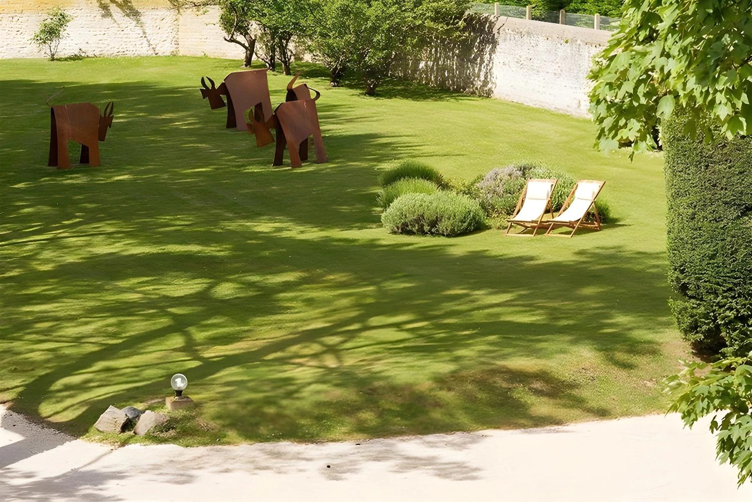 Jardin des Villas d'Arromanches avec sculptures et chaises longues