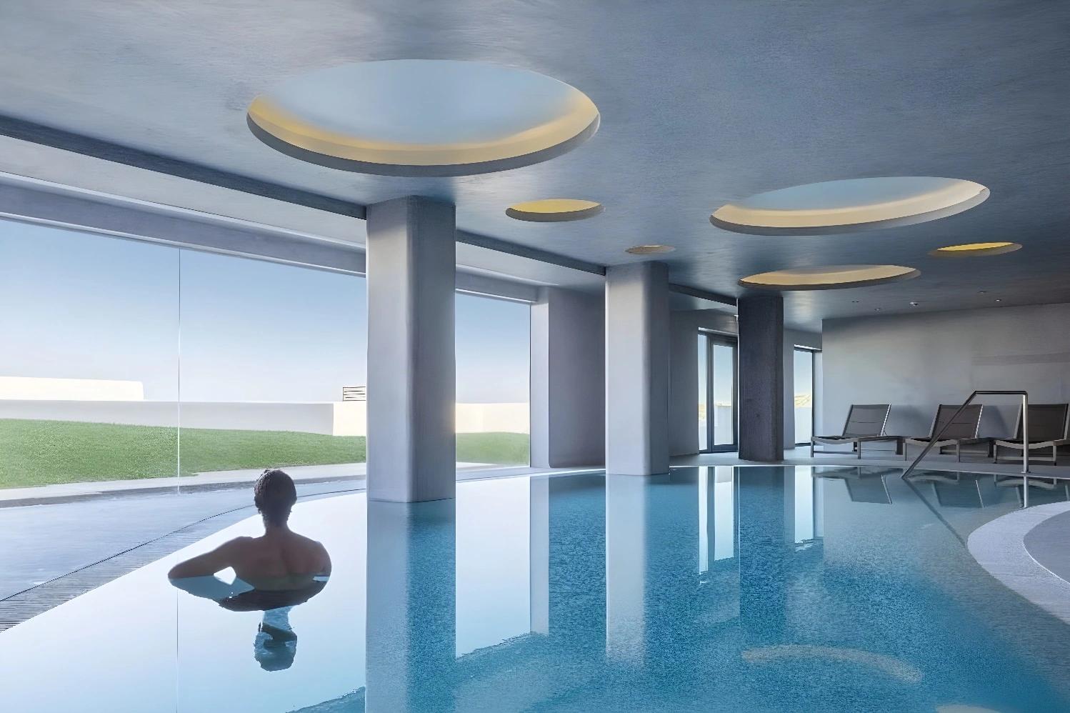 Piscine intérieure de l'hôtel Memmo Baleeira avec vue sur l'extérieur