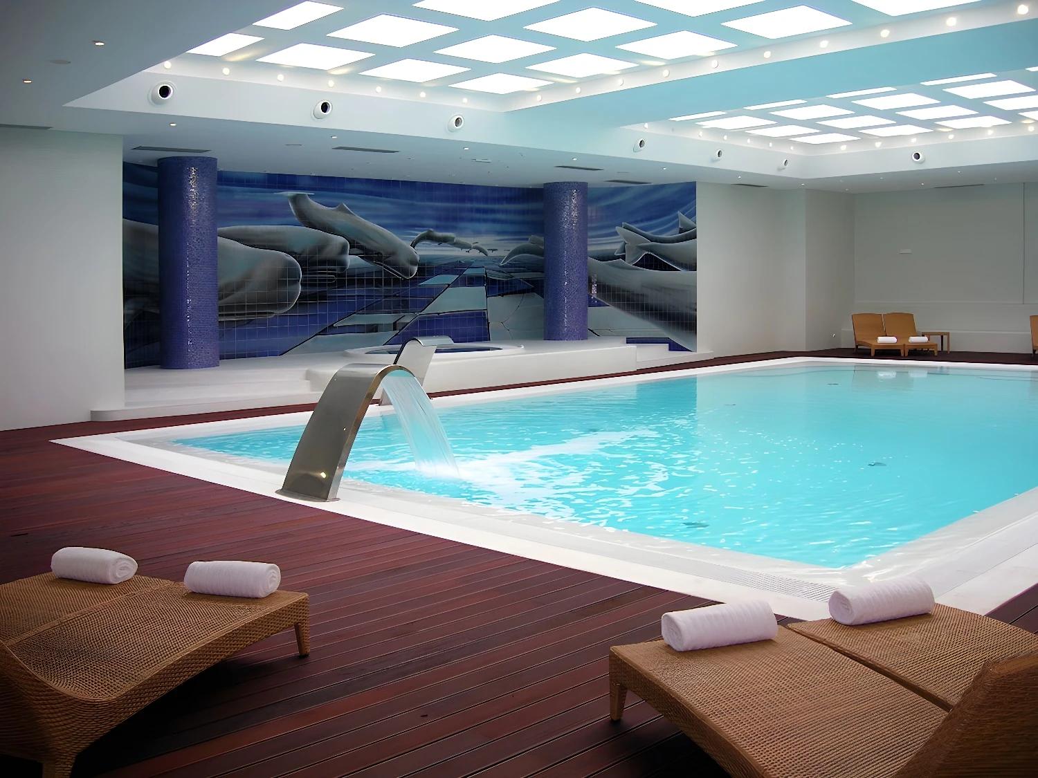 Piscine intérieure de The Prime Energize Monte Gordo avec chaises longues