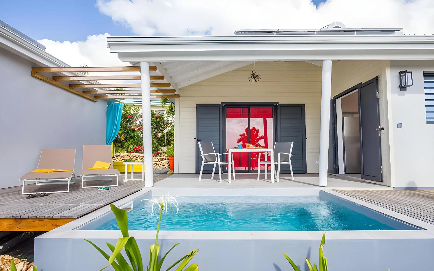 Petite piscine privée à Iguane House Villas & Spa avec chaises longues.