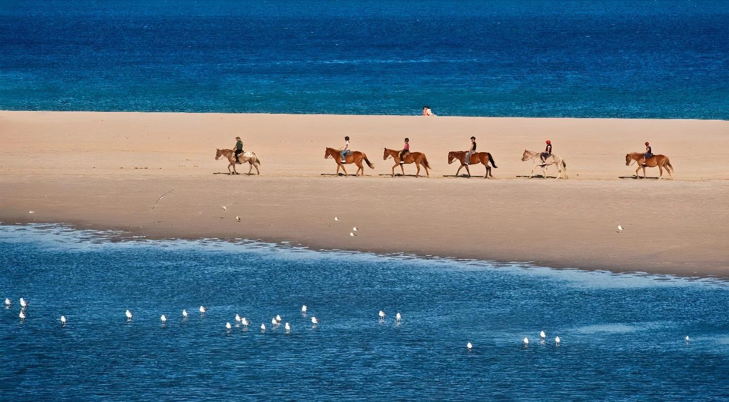 Plage de sable fin près du Chia Laguna - The Village avec une mer turquoise.