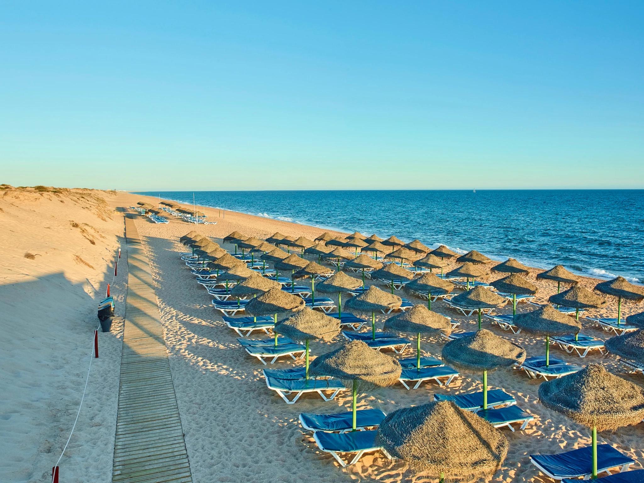 Plage de sable fin avec parasols à l'Hotel Quinta Do Lago.