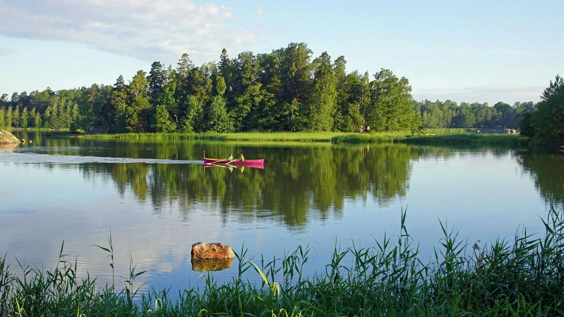 Rameurs sur un lac entouré de verdure pour Aventure Nordique