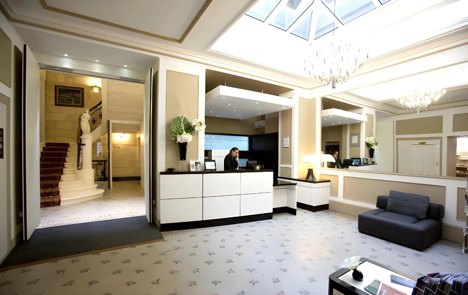 Réception moderne et accueillante du BW Grand Hôtel Français avec un grand lustre.