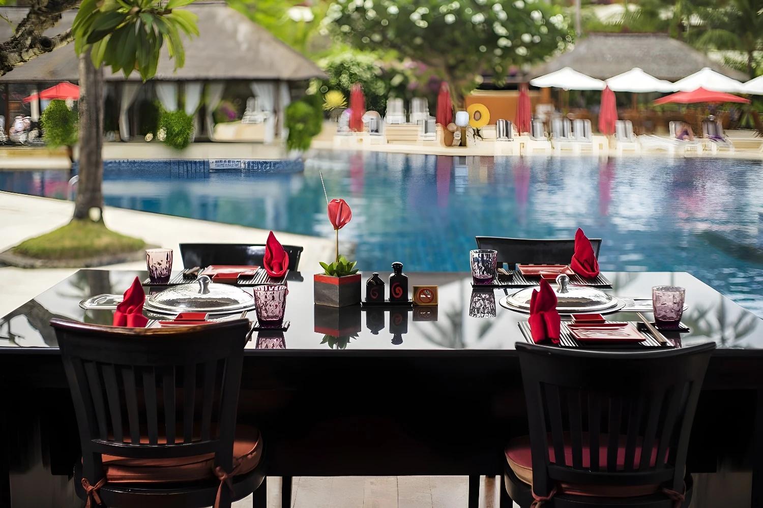 Table dressée pour un repas au bord de la piscine au Nusa Dua Beach Hotel & Spa.