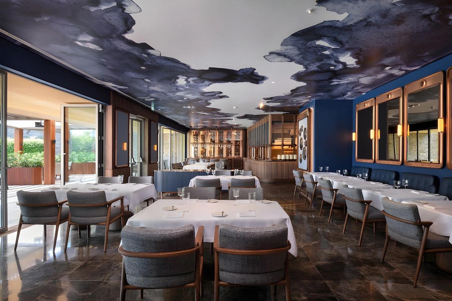 Restaurant élégant de l'Epic Sana Algarve avec un plafond artistique.
