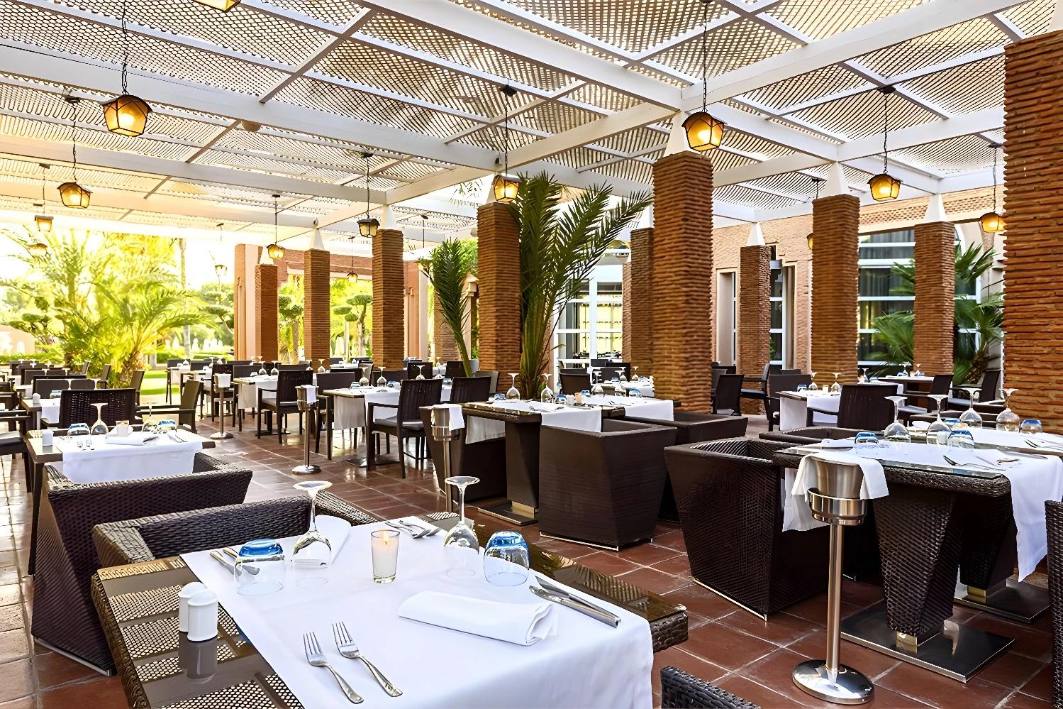 Restaurant extérieur de l'Ôclub Zen Barceló Palmeraie avec tables élégamment dressées.