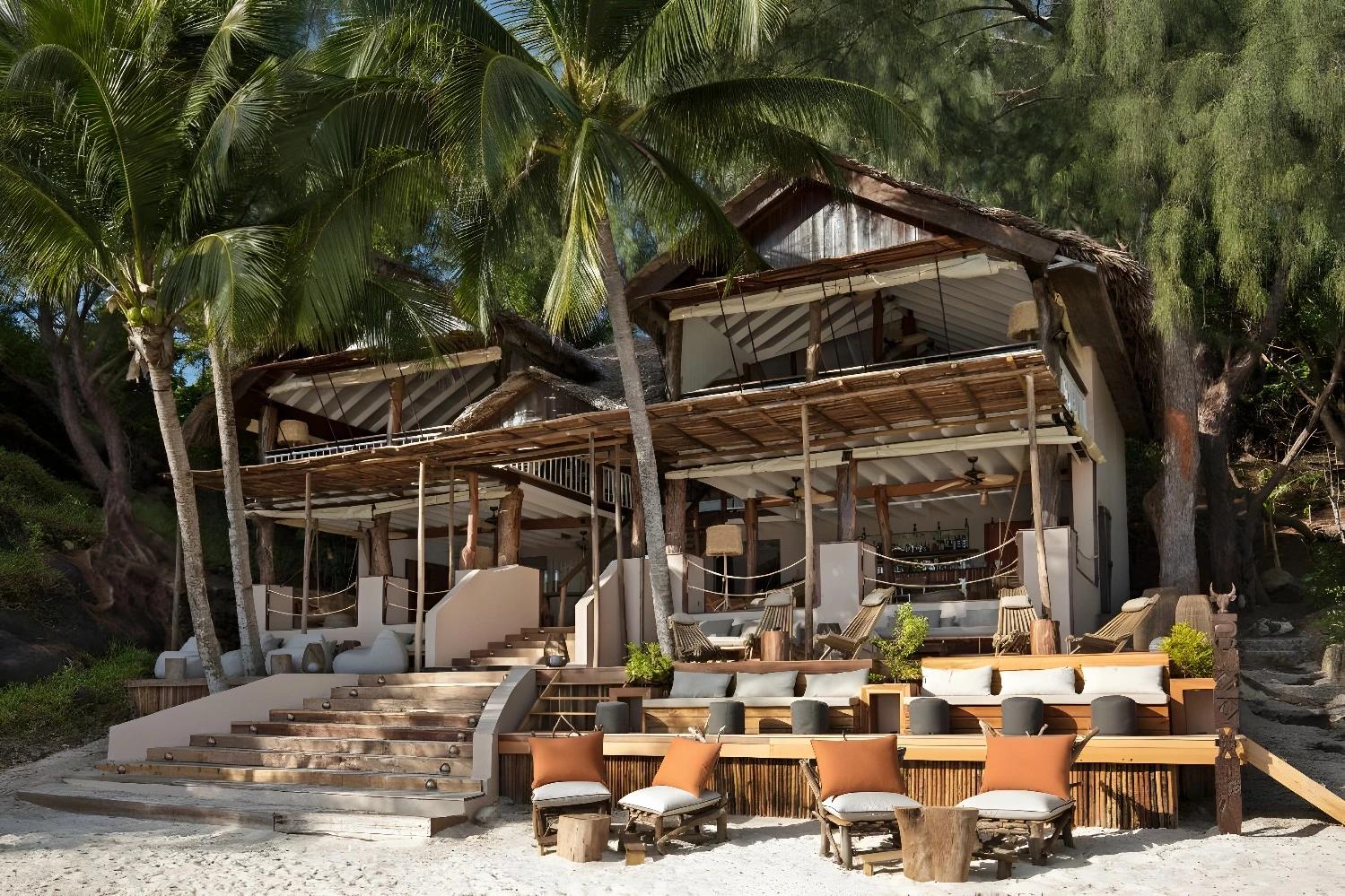Restaurant en bord de plage à Constance Tsarabanjina Madagascar avec des palmiers.