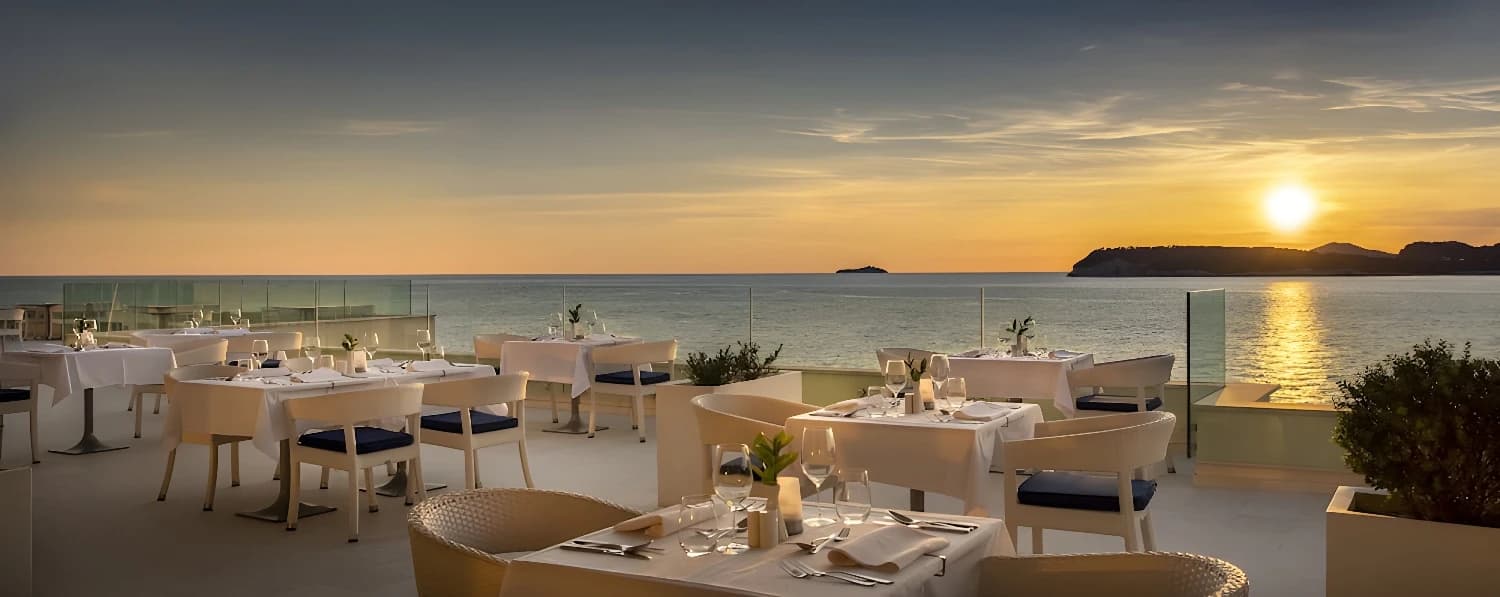 Restaurant en terrasse du Valamar Collection Dubrovnik President avec vue sur le coucher de soleil.