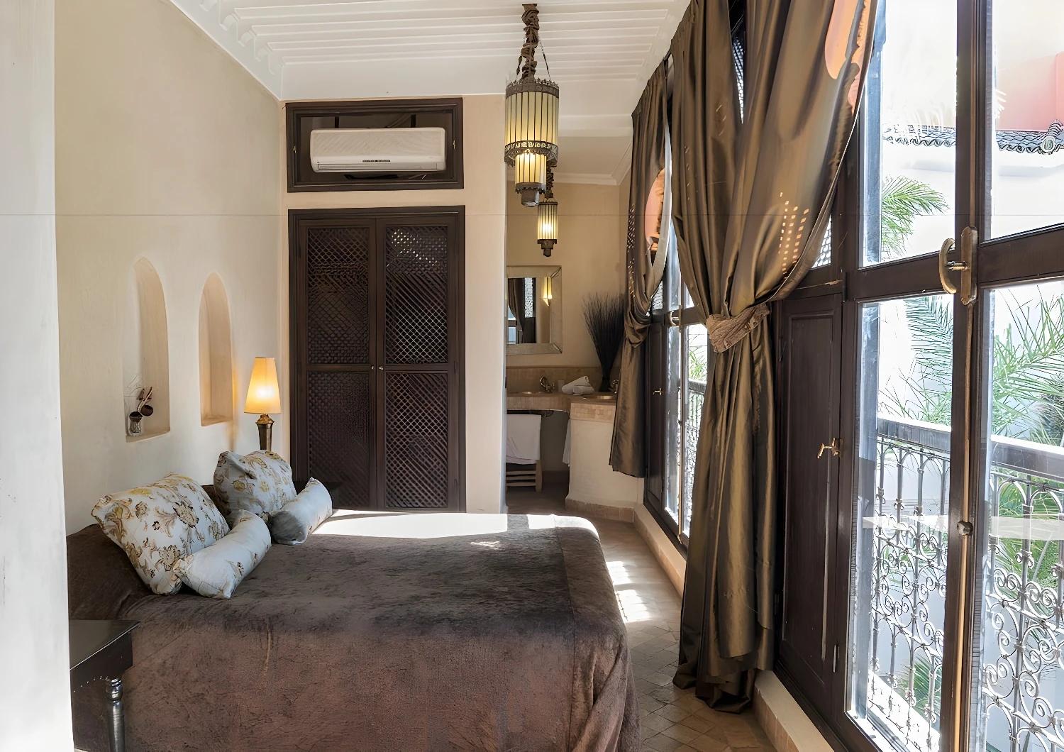 Chambre lumineuse du Riad Dar Saad avec vue sur le balcon.