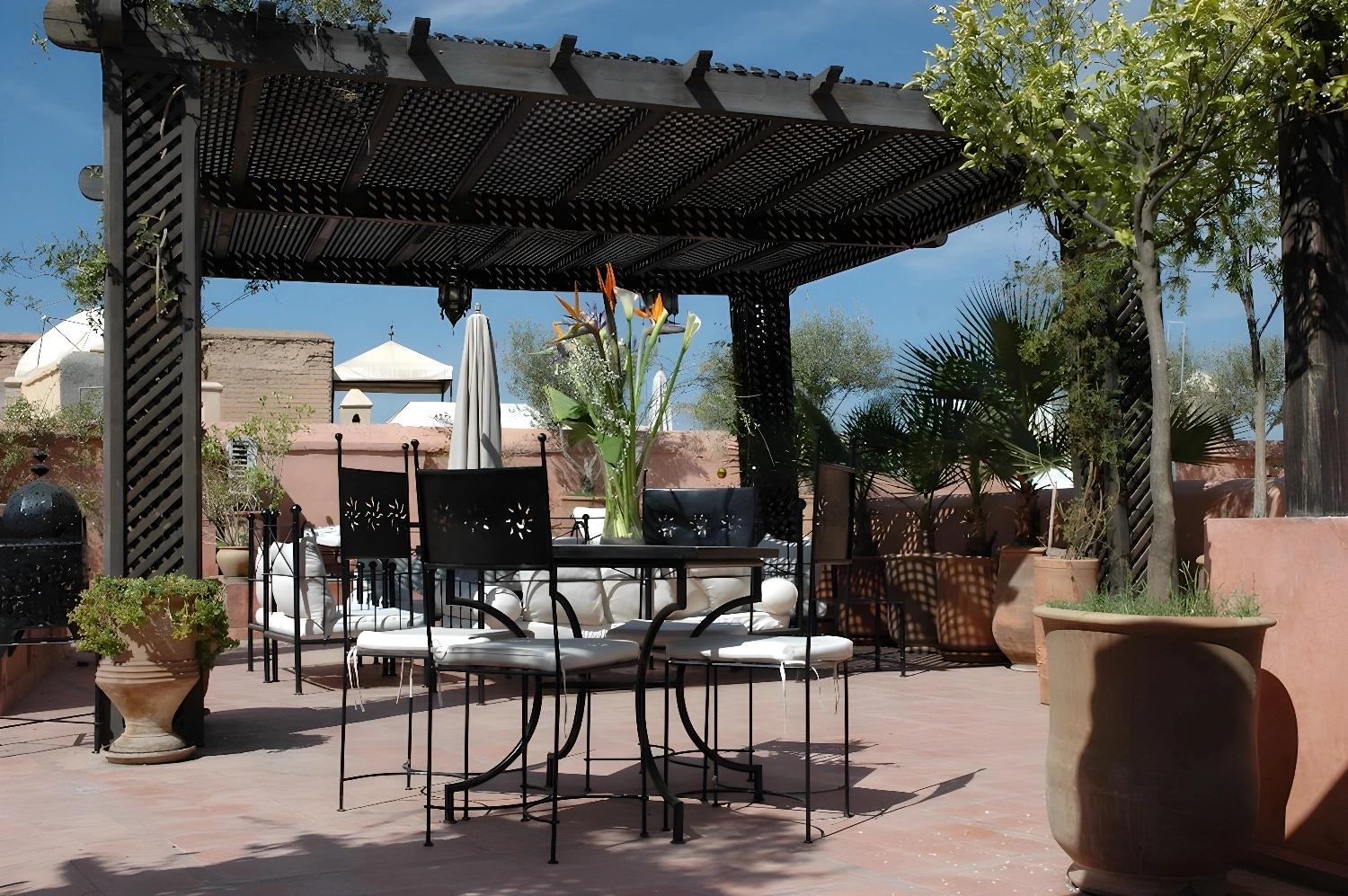Terrasse ensoleillée du Riad Dar Saad avec pergola et mobilier extérieur.