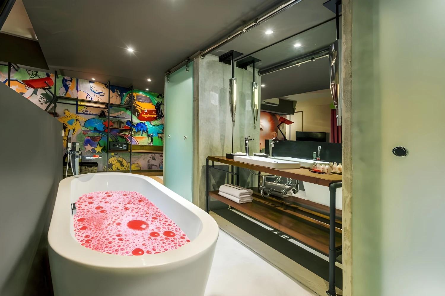 Salle de bain élégante du Dash Seminyak avec baignoire et décoration artistique.