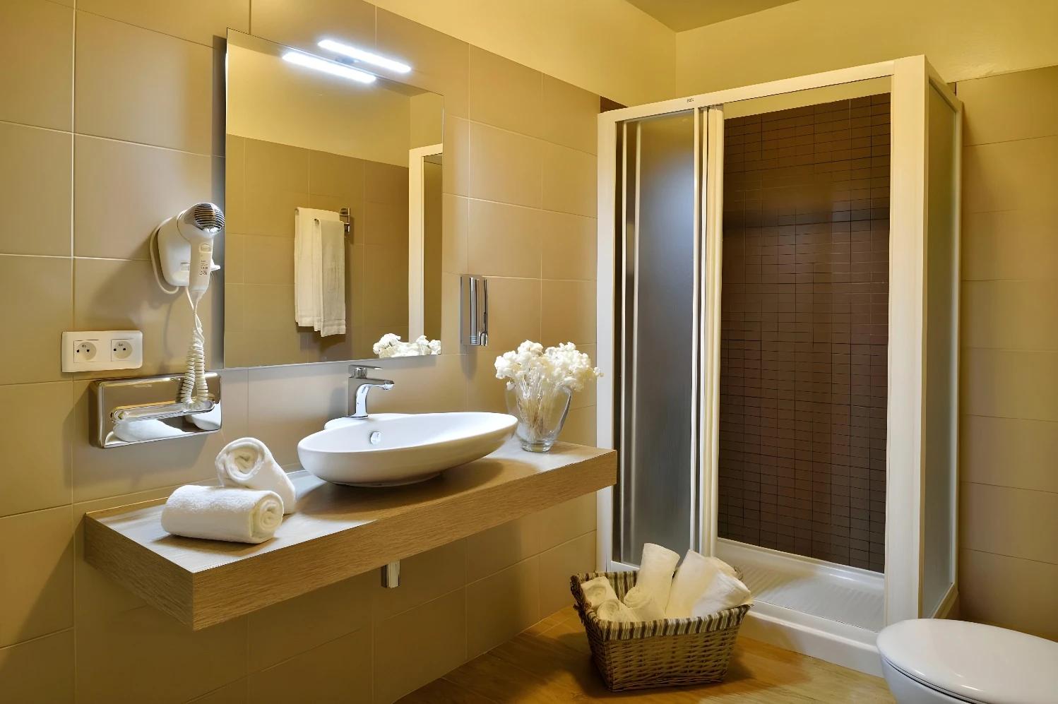 Salle de bain élégante de l'Hotel Fesch & Spa avec douche moderne.