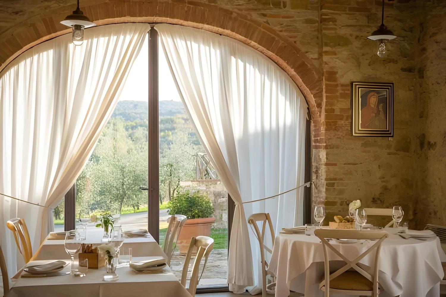 Salle à manger élégante du Castello di Gabbiano avec vue sur le jardin.
