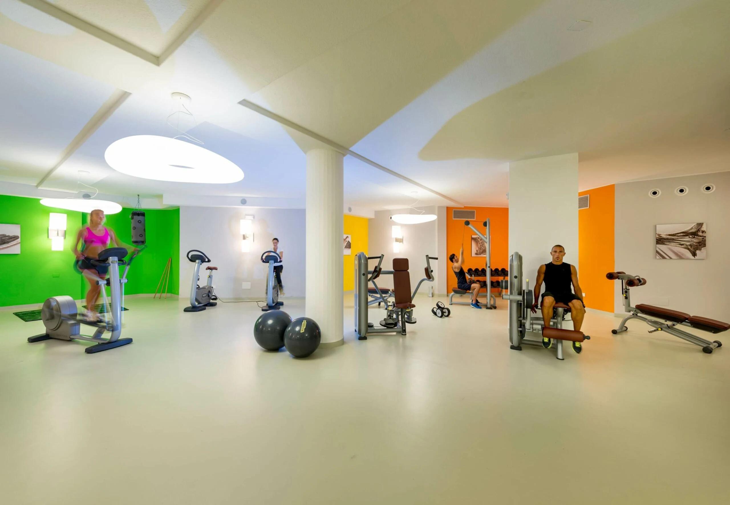 Salle de sport moderne au Chia Laguna - The Village avec équipements variés.