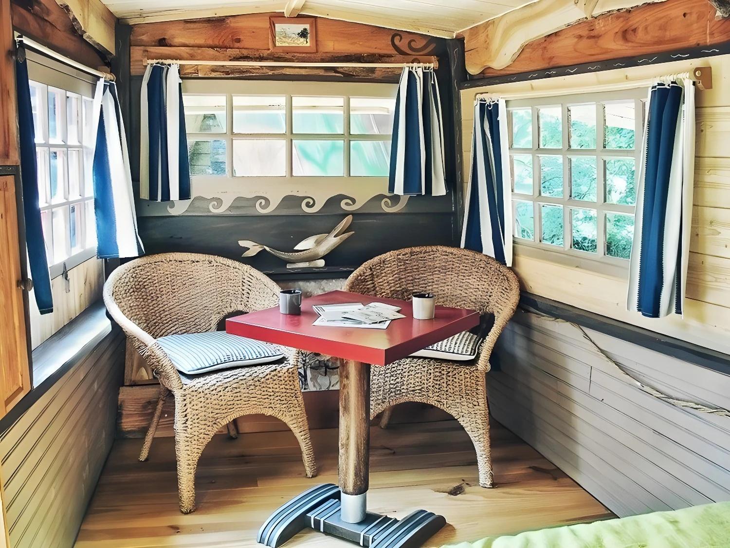 Salon intérieur du P'tit Gris des Moulins avec table rouge