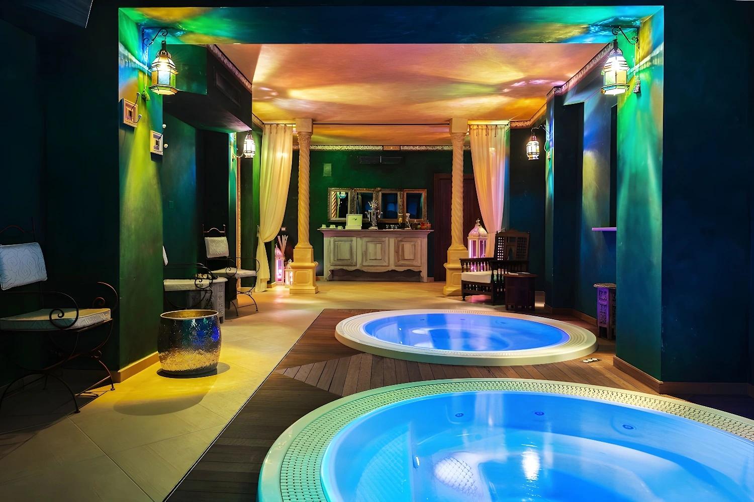 Intérieur du spa au Relais Sassa al Sole avec jacuzzi et éclairage coloré.