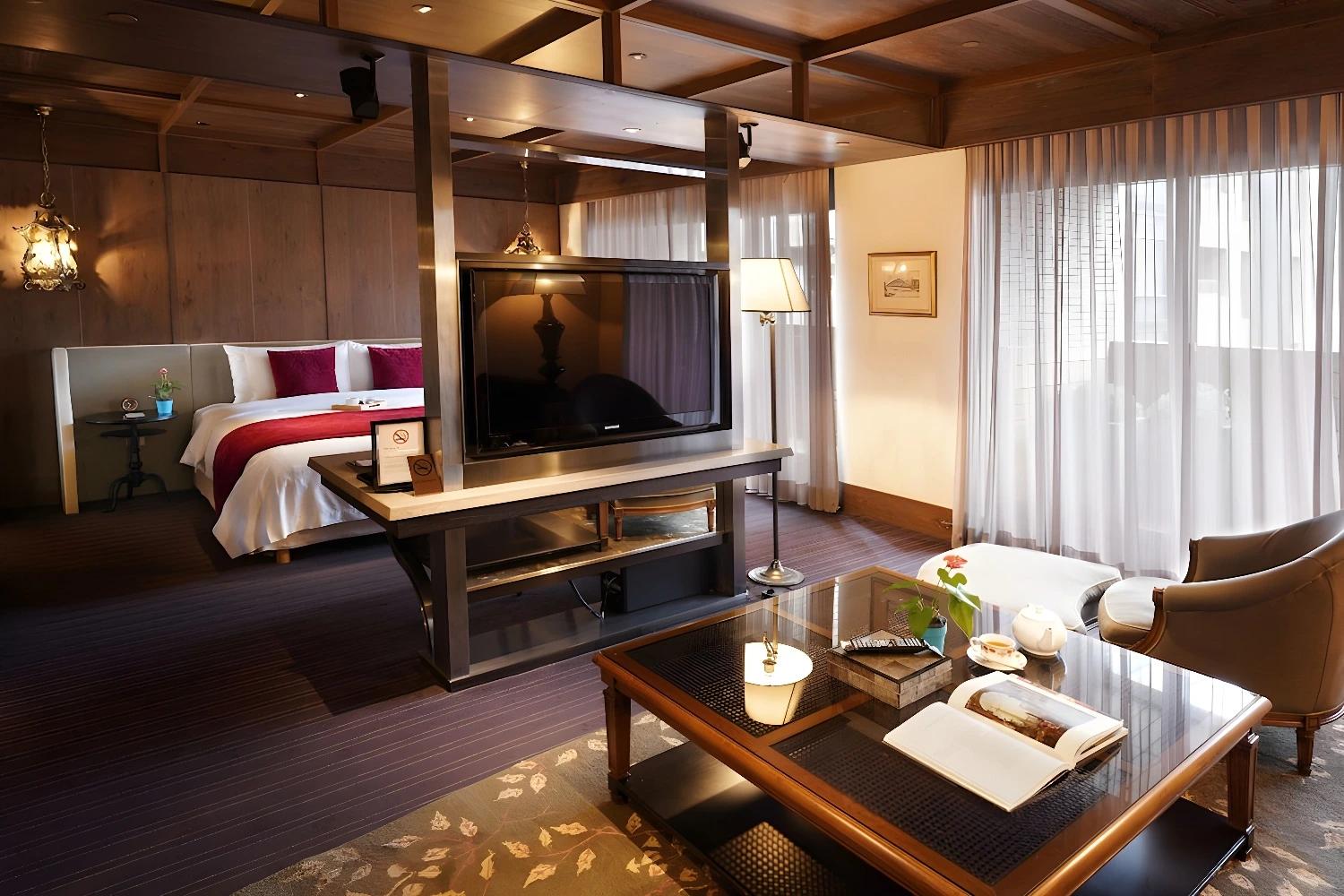 Suite spacieuse au Palais De Chine Hotel avec un coin salon et une télévision moderne.