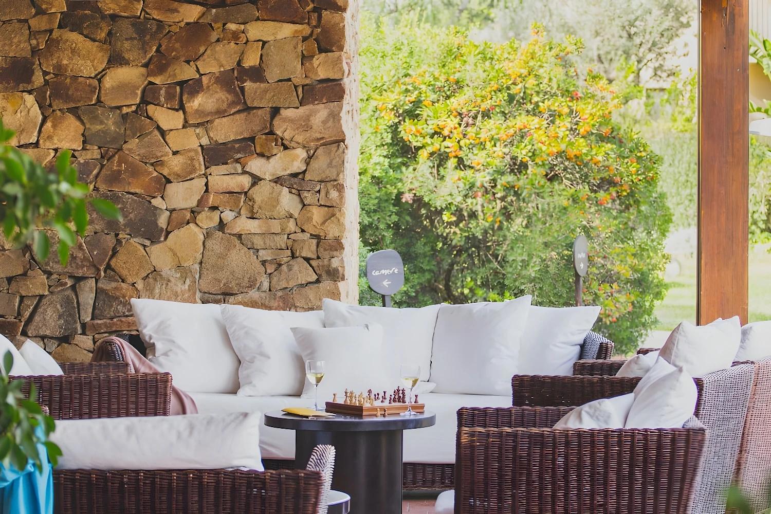 Terrasse extérieure de l'hôtel Aquadulci avec mobilier en osier.