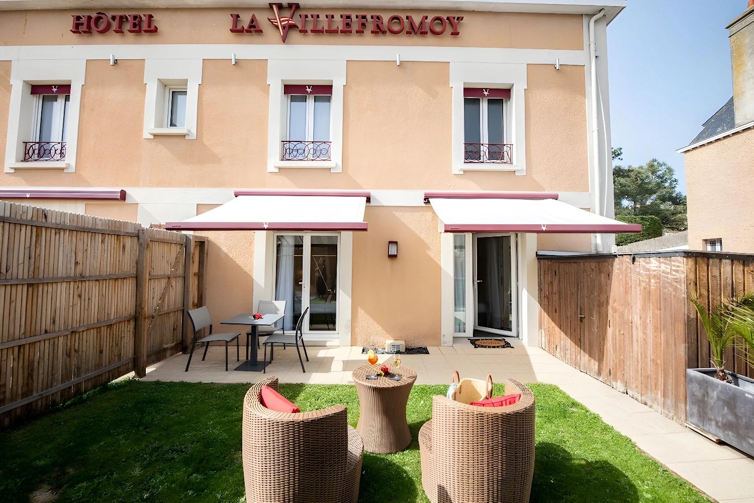Terrasse extérieure de l'hôtel La Villefromoy avec mobilier confortable.