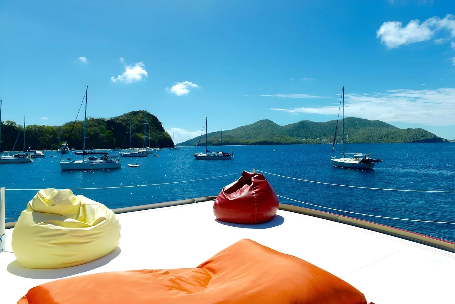 Vue depuis le toit de l'Aqua Lodge avec poufs colorés et paysage marin.