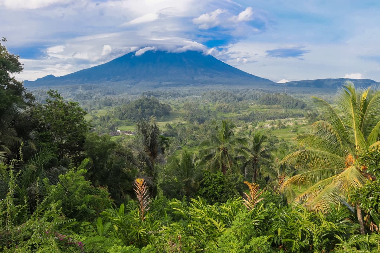 Vue sur le Mont Agung à Bali, entouré de verdure luxuriante et d'une atmosphère paisible.