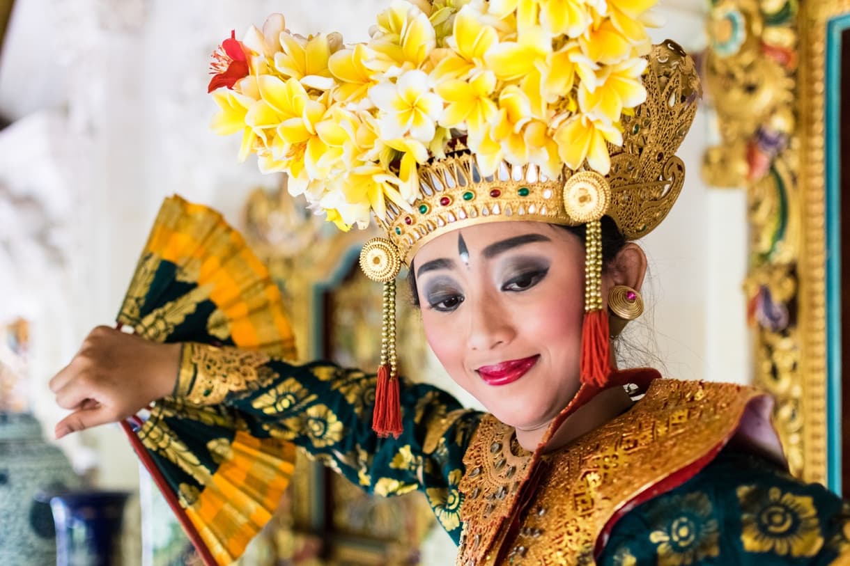 Danseuse balinaise en costume traditionnel avec un éventail et des fleurs dans les cheveux, Bali, Indonésie