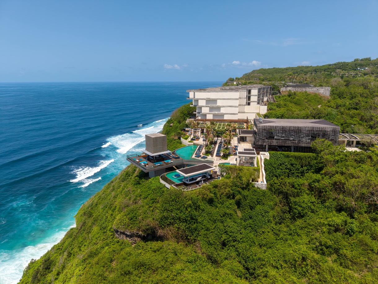 Complexe hôtelier moderne surplombant l'océan, avec piscines et végétation en bord de mer à Bali