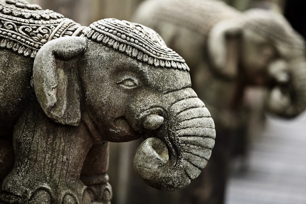 Élégante statue d'éléphant en pierre, ornée de motifs, représentant la culture balinaise.